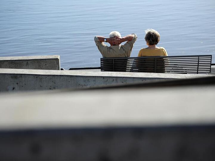 Ein Senioren-Paar auf einer Bank an der Elbe. Seit Juli 2014 können Arbeitnehmer nach mindestens 45 Jahren Einzahlung in die Rentenkasse bereits ab 63 Jahren abschlagsfrei in Rente gehen.
