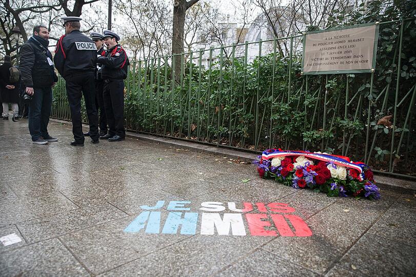 Am ersten Jahrestag der Anschläge auf die Satirezeitschrift Charlie Hebdo erinnert ein Hologramm auf dem Bürgersteig an den erschossenen Wachmann, der sich den Attentätern in den Weg stellte.