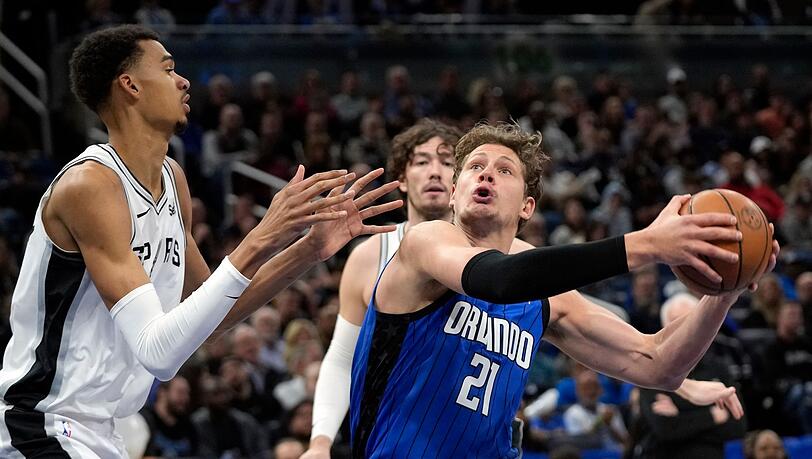 Orlandos Center Moritz Wagner (21) zieht gegen Spurs Center Victor Wembanyama (l) zum Korb.