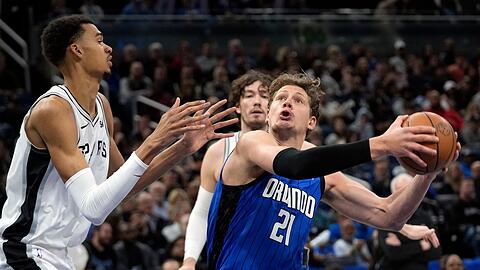 Orlandos Center Moritz Wagner (21) zieht gegen Spurs Center Victor Wembanyama (l) zum Korb.