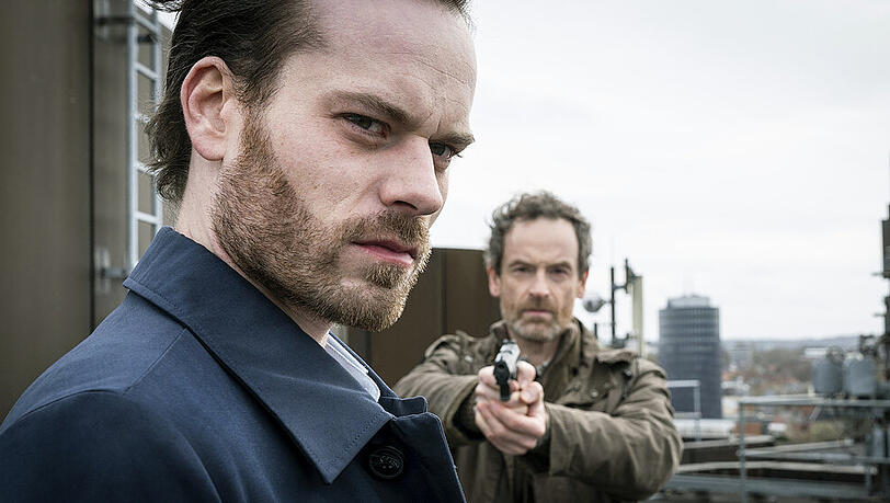 "Tatort: Monster": Peter Faber (Jörg Hartmann) hat seine Waffe auf Markus Graf (Florian Bartholomäi) gerichtet "Tatort: Monster": Peter Faber (Jörg Hartmann) hat seine Waffe auf Markus Graf (Florian Bartholomäi) gerichtet