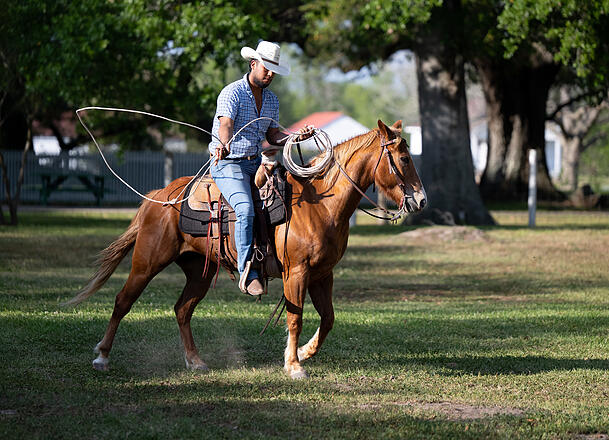 Ein Cowboy reitet bei dem Besuch auf der George Ranch.