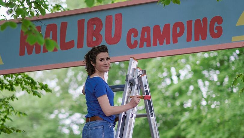 "Malibu: Ein Zelt für drei": Jantje (Karla Nina Diedrich) verpasst dem Eingang von "Malibu Camping" einen neuen Anstrich.