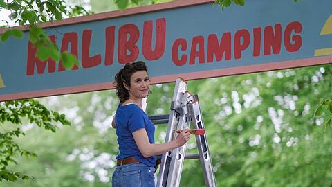 "Malibu: Ein Zelt für drei": Jantje (Karla Nina Diedrich) verpasst dem Eingang von "Malibu Camping" einen neuen Anstrich.