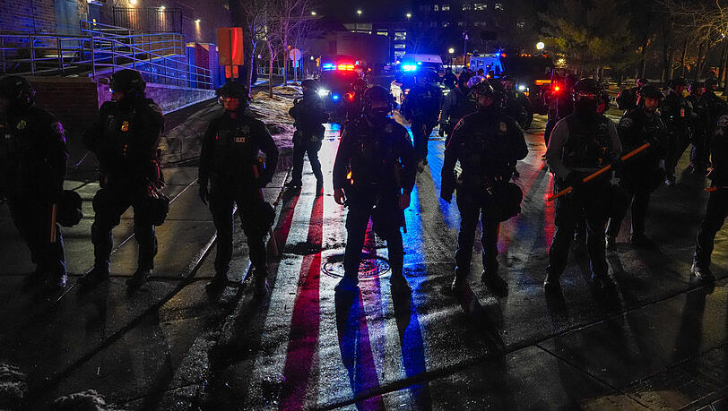 Polizeibeamte aus Minneapolis bewachen während einer „Lärmdemonstration“ ein Hotel, in dem Beamte der Einwanderungsbehörde ICE untergebracht sind. Polizeibeamte aus Minneapolis bewachen während einer „Lärmdemonstration“ ein Hotel, in dem Beamte der Einwanderungsbehörde ICE untergebracht sind.