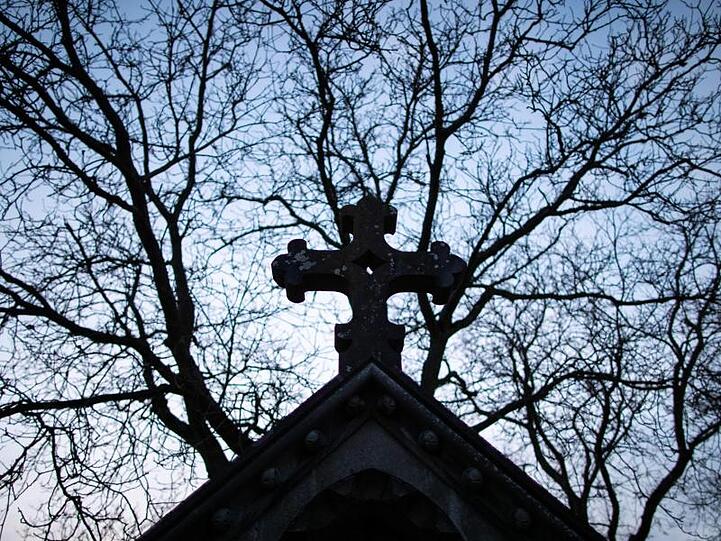 Ein Kreuz aus Stein auf dem Städtischen Friedhof in Rothenburg ob der Tauber. Foto: Daniel Karmann