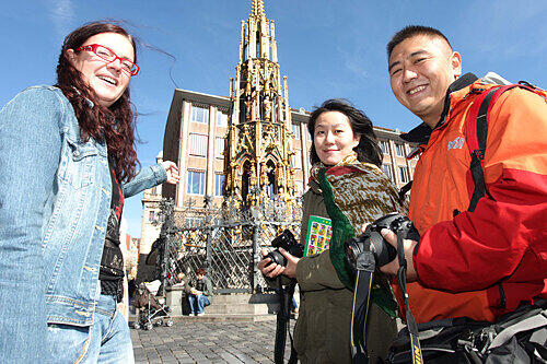Simone Frühaber zeigt ihren Couchsurfern Cao Shuang (links) und Hui Zhao den Schönen Brunnen am Hauptmarkt.