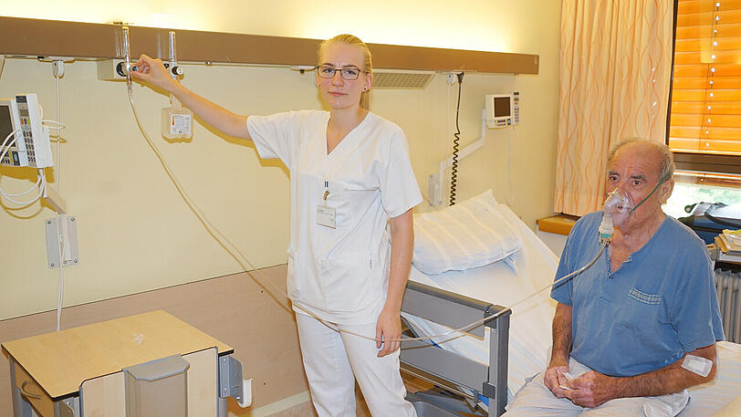 Der Patient hat Probleme, zu atmen &ndash; die Pflegeschülerin hilft.