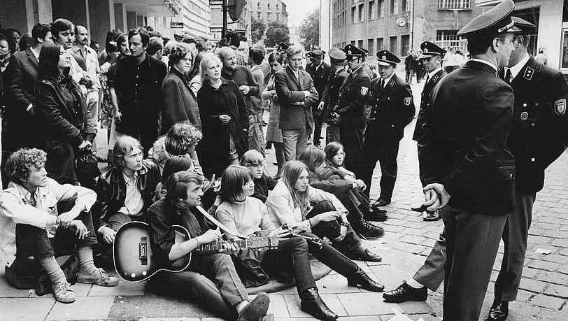 Bei dieser Demo treten ein paar Münchner Studenten in der Feilitzschstraße den Sitzstreik – die Polizisten bleiben gelassen. Bei dieser Demo treten ein paar Münchner Studenten in der Feilitzschstraße den Sitzstreik – die Polizisten bleiben gelassen.