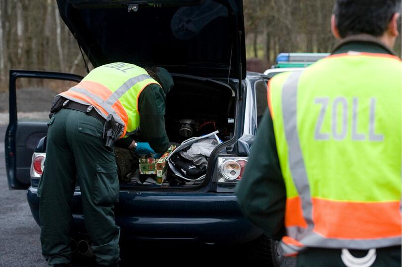 Ein Zollbeamter durchsucht bei Selb unweit der deutsch-tschechischen Grenze bei einer Kontrolle den Kofferraum eines Pkw, während sein Kollege ihn sichert. Schwerpunkt der Aktion war die Suche nach der Modedroge "Crystal".