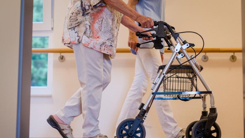 Eine Pflegekraft geht in einem Pflegeheim mit einer älteren Dame über einen Korridor. Foto: Christoph Schmidt/dpa/Symbolbild Eine Pflegekraft geht in einem Pflegeheim mit einer älteren Dame über einen Korridor. Foto: Christoph Schmidt/dpa/Symbolbild