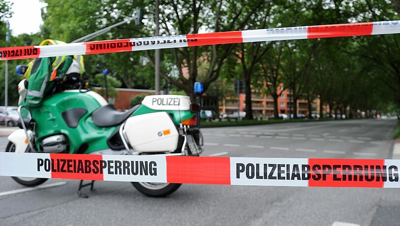 Ein Polizei-Motorrad steht auf einer leeren und gesperrten Hauptverkehrsstraße. Ein Polizei-Motorrad steht auf einer leeren und gesperrten Hauptverkehrsstraße.