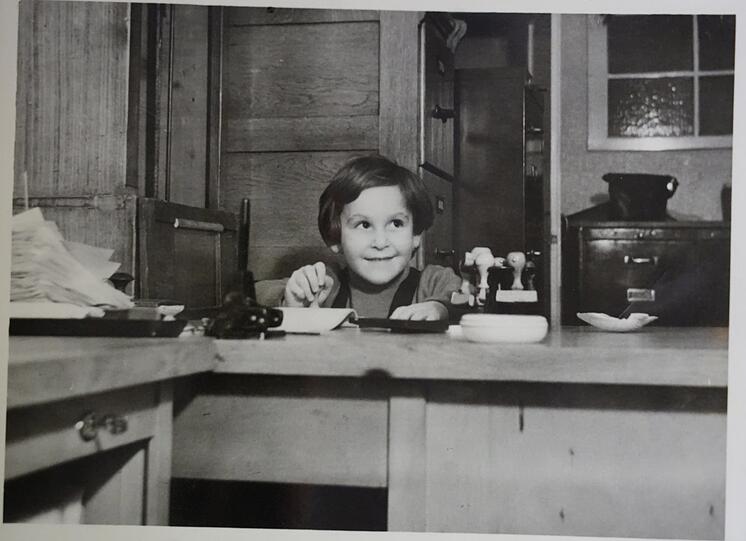 Im Stockwerk über dem Laden wohnt die Familie. Hier sitzt Ursula 1952 am Bürotisch vom Papa.