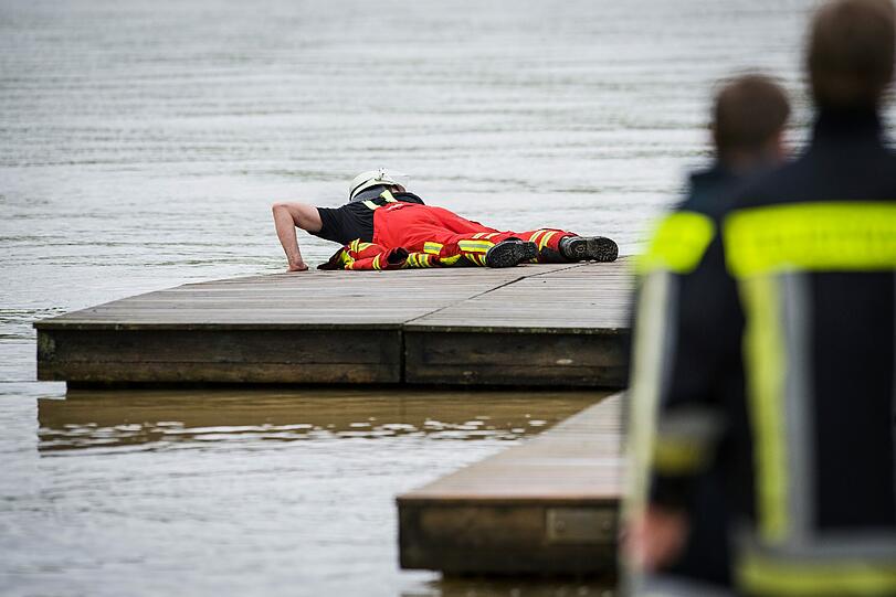Auf dem nahen Baggersee lösen Feuerwehrmänner einen Bade-Ponton.
