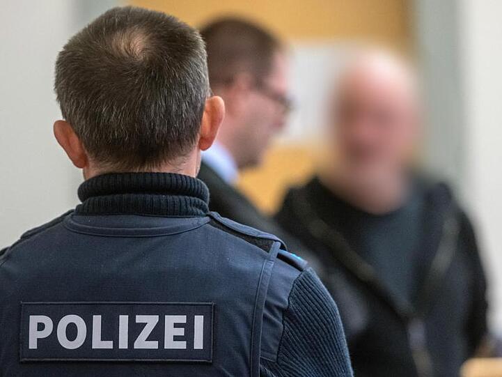 Der Angeklagte (r) steht im Verhandlungssaal des Landgerichts. Foto: Armin Weigel/dpa