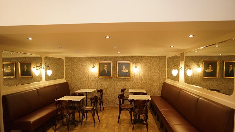 Traditionelle Kaffeehaus-Stühle im Stile Thonets und eine opulente Jugendstiltapete schaffen ein 20er-Jahre-Ambiente. Traditionelle Kaffeehaus-Stühle im Stile Thonets und eine opulente Jugendstiltapete schaffen ein 20er-Jahre-Ambiente.