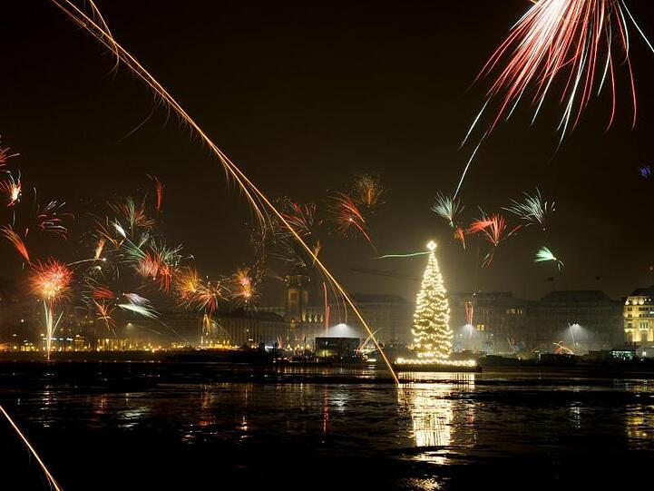 Silvesterraketen erleuchten den Himmel über der Binnenalster in Hamburg.