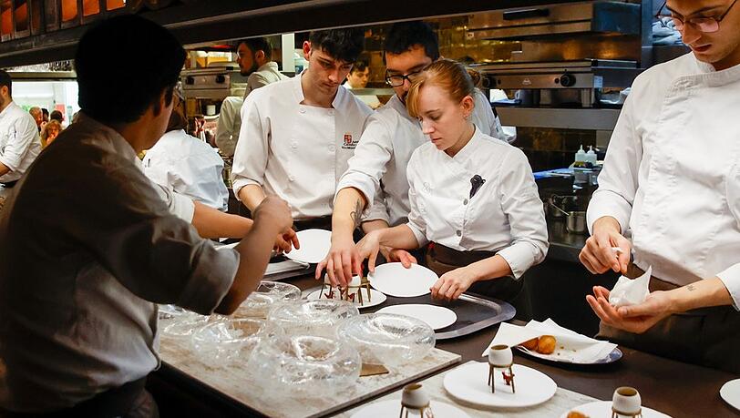 Mitarbeiterinnen und Mitarbeiter im Disfrutar, dem besten Restaurant der Welt, bereiten Speisen zu.