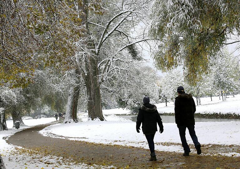 Spaziergänger müssen sich heute warm einpacken - Schnee im Englischen Garten.
