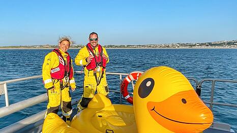 Einsatzkräfte der Rettungsgesellschaft RNLI mit der aufblasbaren Ente "Quakers", die auch gerettet wurde.