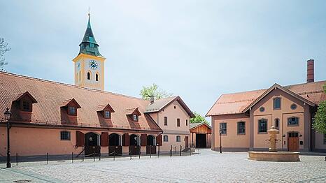 Dorf-Mittelpunkt: Der Brunnen ist der Treffpunkt f&uuml;r F&uuml;hrungen. Dahinter ist die Brennerei zu sehen, links der Pferdestall.