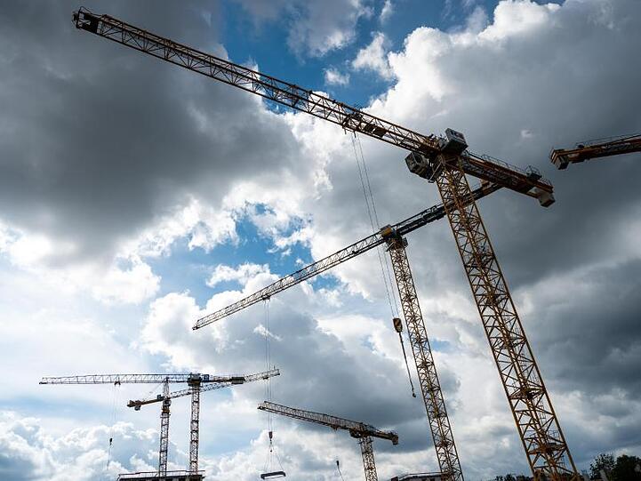 Auf einer Baustelle in Berlin stehen Baukräne. (Symbolbild).