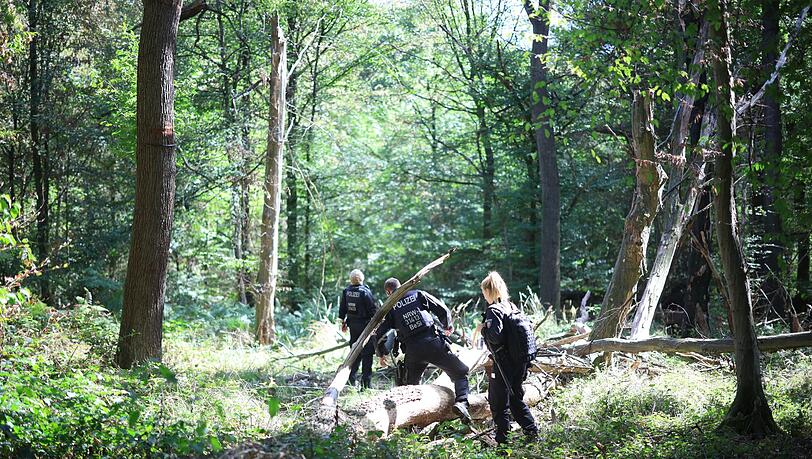 Die Polizei sucht mitten im Wald nach dem Verd&auml;chtigen.