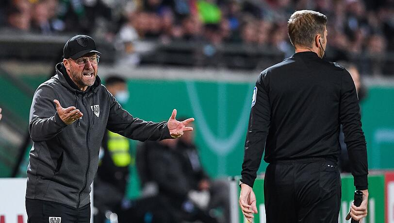Münsters Trainer Sascha Hildmann (l) diskutiert mit dem Linienrichter.