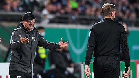 Münsters Trainer Sascha Hildmann (l) diskutiert mit dem Linienrichter.