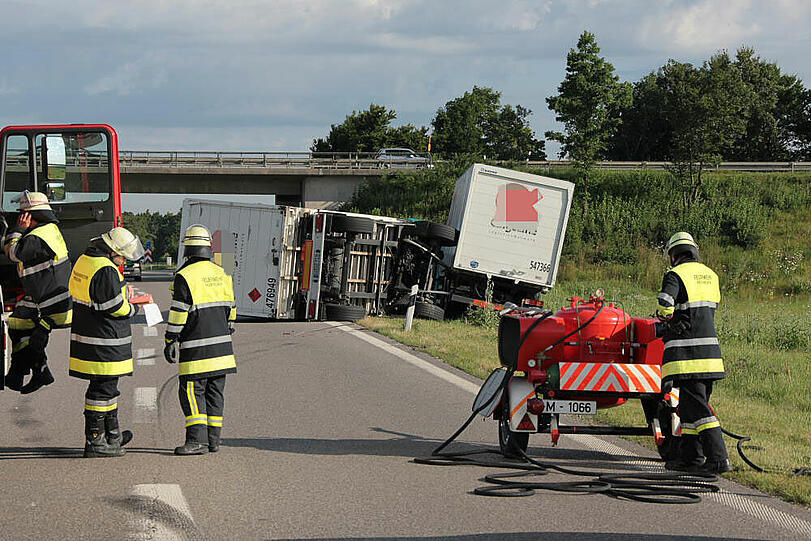 Vermutlich weil er zu schnell auf die Autobahn fährt, kommt ein Laster in der Kurve von der Fahrbahn ab und fährt in die Leitplanke. Sein Hänger kippt um.