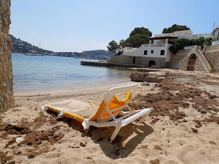 Eine Liege steht auf einem leeren Strand auf Mallorca.
