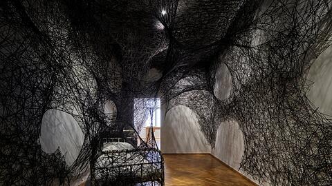 Alles hängt zusammen: Die Spezialität der japanischen Künstlerin Chiharu Shiota sind feine Netze. Die Installation "During Sleep" von 2023 ist noch bis zum 11. Februar in der Ausstellung "Kafka: 1924" im Museum Villa Stuck zu sehen.