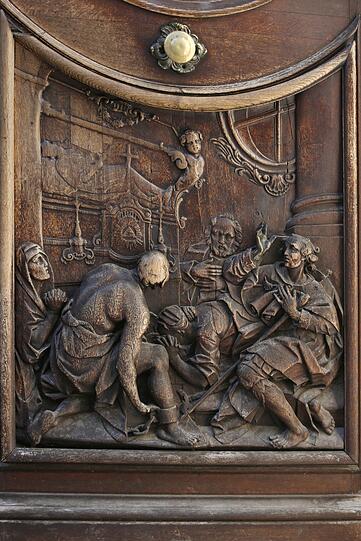Schnitzarbeit: Detail aus dem prächtigen Portal der Asamkirche, das Szenen aus dem Leben des Heiligen Johannes von Nepomuk zeigt.