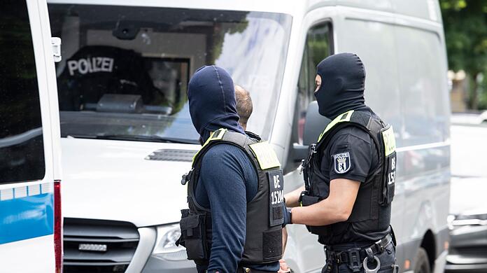 Polizisten führen einen Mann ab. Mit einer  Razzia ist die Polizei in Berlin gegen den organisierten Drogenhandel vorgegangen.