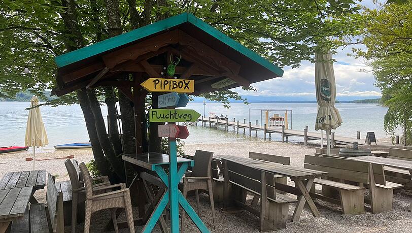 B&auml;nke, Liegest&uuml;hle, Sonnenschirme direkt am Strand: Der Kiosk &bdquo;Steg 1&ldquo; (mit Steg im Hintergrund) lockt viele M&uuml;nchner an den Starnberger See.