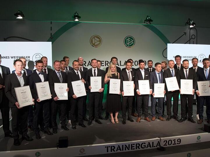 Die Trainer des Fußballlehrer-Lehrgangs stehen mit DFB-Präsident Reinhard Grindel (l) beim Gruppenfoto zusammen.