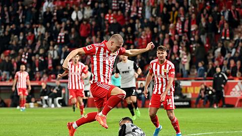 Julian Ryerson (l) von Union und Iago (unten, liegend) vom FC Augsburg im Zweikampf.