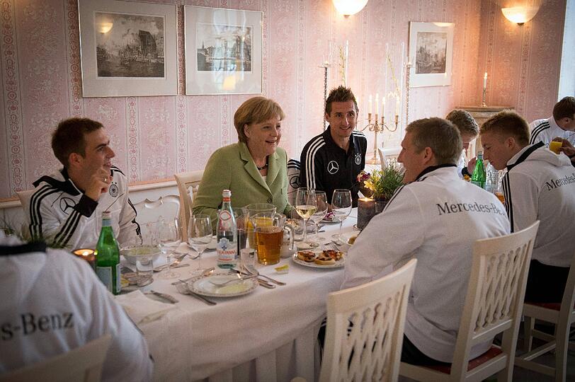 Prominente Tischnachbarin: Kanzlerin Merkel inmitten der Nationalspieler Lahm, Klose und Schweinsteiger.