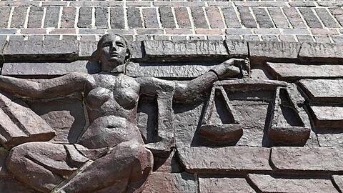 Blick auf die Justitia über dem Eingang eines Landgerichts.
