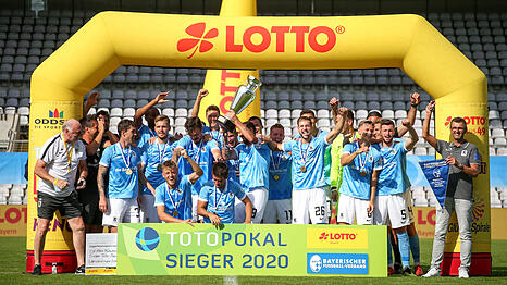 Der TSV 1860 als Totopokal-Sieger 2020. Der damalige Kapit&auml;n Sascha M&ouml;lders (Mitte) stemmt den Pokal, Trainer Michael K&ouml;llner (r.) jubelt mit Sieger-Wimpel und Daniel Wein (6.v.l.) freut sich im Stillen.