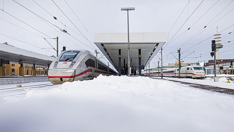 Zwei ICE stehen im verschneiten Hauptbahnhof Hannover.