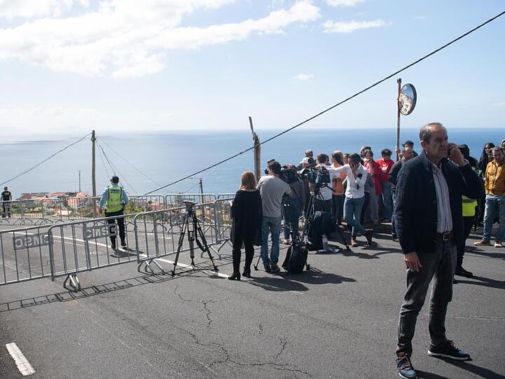 Polizisten, Journalisten, Einheimische und Touristen an der Kante, über die der Reisebus in die Tiefe gestürzt war.