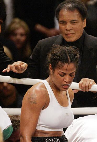 Einmal Boxer, immer Boxer: Ali (hinten) sieht am 17.12.2005 in Berlin in der Max-Schmeling-Halle seiner Tochter, der Supermittelgewichts-Weltmeisterin Laila Ali (USA, M), nach ihrem Kampf gegen die Schwedin Asa Sandell vom Ring nach dem Boxkampf hinterher.