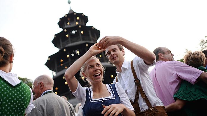 Ein Paar beim Kocherlball am Chinesischen Turm. Viele Besucher sind jung.