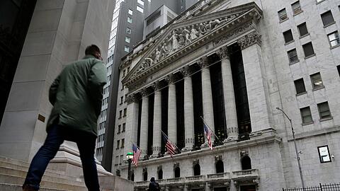 Menschen passieren die Fassade der New Yorker Börse.