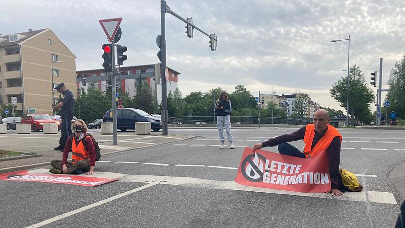 Aktivisten der "Letzten Generation" kleben sich aus Protest auf der Fahrbahn fest. Aktivisten der "Letzten Generation" kleben sich aus Protest auf der Fahrbahn fest.