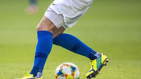Ein Fußballspieler spielt den Ball.