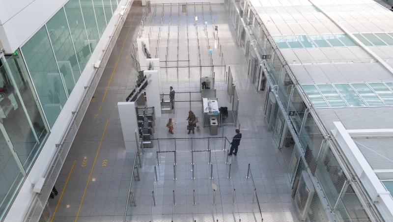 Sicherheitspersonal wartet an der Gepäckkontrolle am Flughafen München auf die wenigen Passagiere. Foto: Peter Kneffel/dpa Sicherheitspersonal wartet an der Gepäckkontrolle am Flughafen München auf die wenigen Passagiere. Foto: Peter Kneffel/dpa