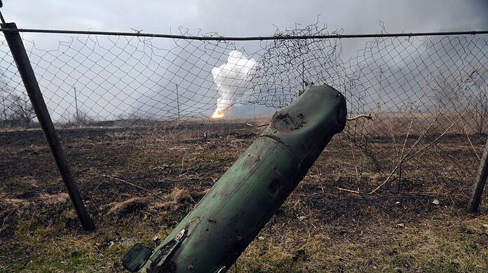 Der Teil einer Rakete liegt auf dem Boden vor einem brennenden Munitionslager in der Nähe der ostukrainischen Stadt Balaklija (Ukraine).