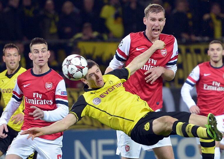 Dortmunds Robert Lewandowski (vorn) kämpft gegen Arsenals Per Mertesacker (M) und Laurent Koscielny (l) um den Ball.